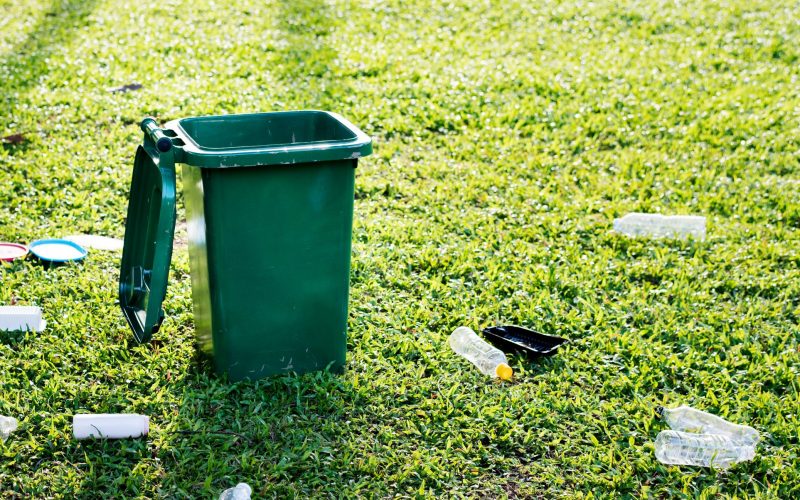 recycling-campaign-with-green-bin-wasted-plastic-bottles-field